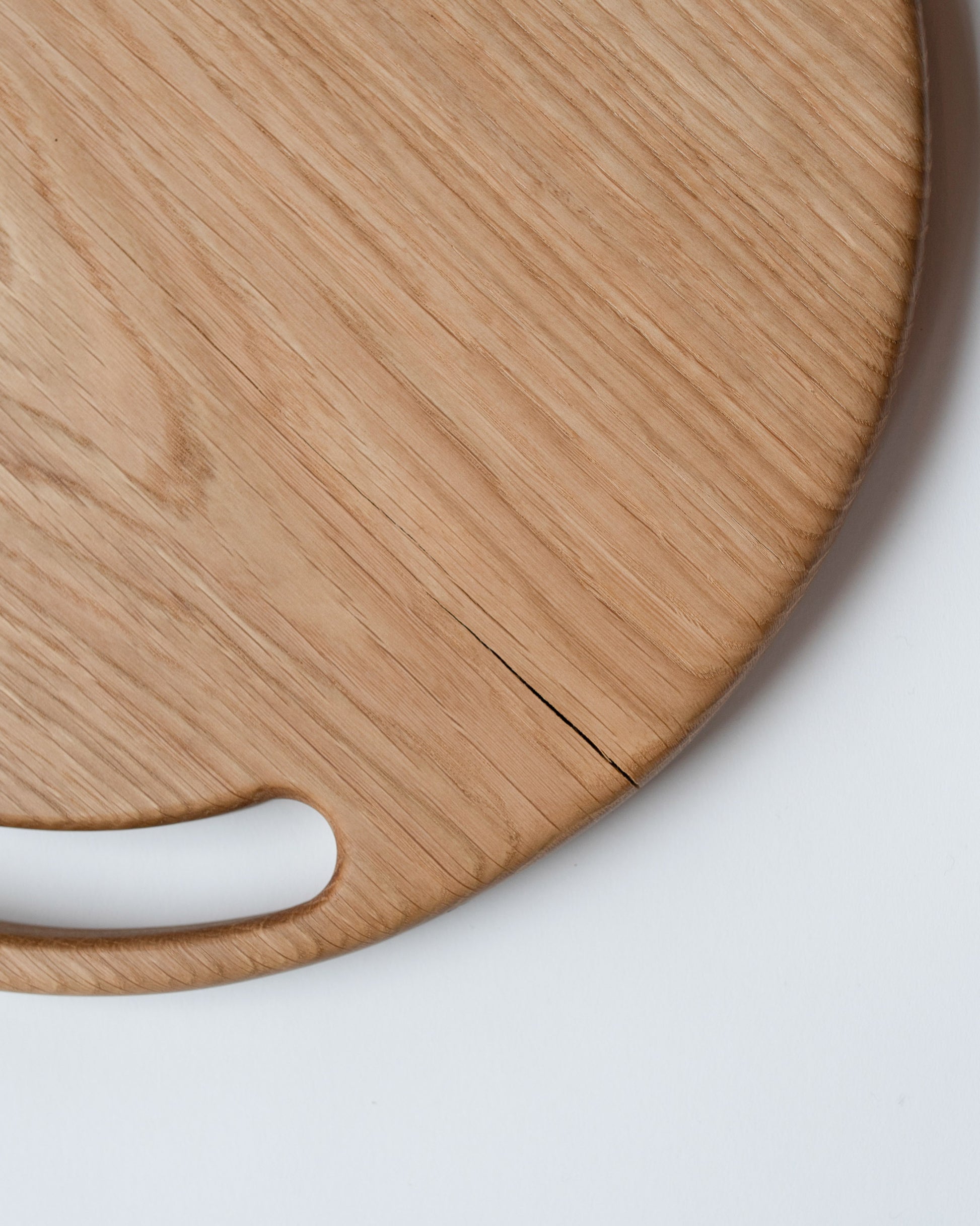 Closeup details of the Lucas Castex No. 08 Hand-Carved Oak Wood Serving Board on light color background.