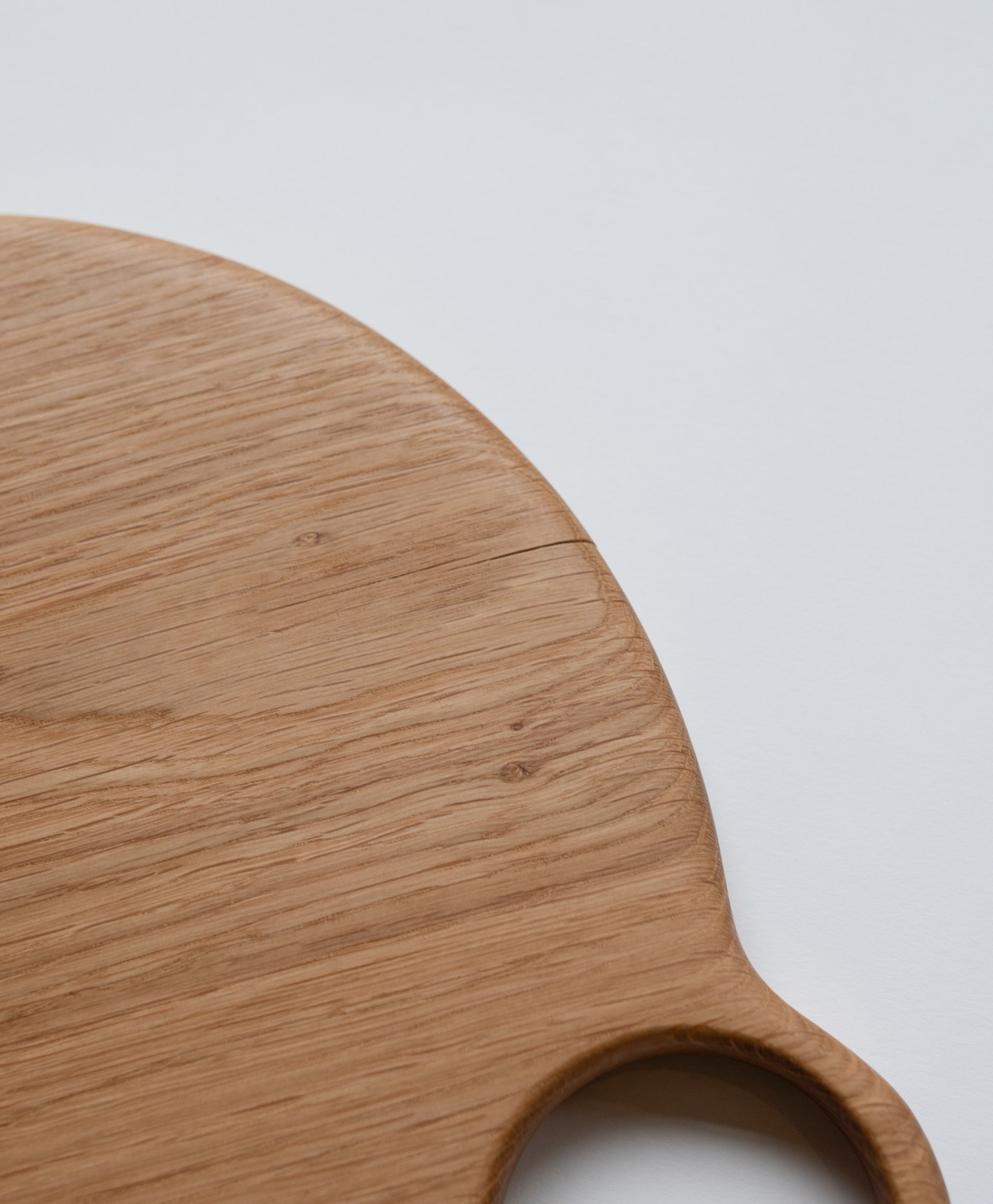 Closeup details of the Lucas Castex No. 10 Hand-Carved Oak Wood Serving Board on light color background.