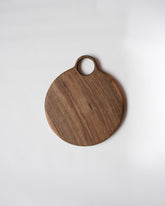 Lucas Castex No. 10 Hand-Carved Walnut Wood Serving Board on light color background.
