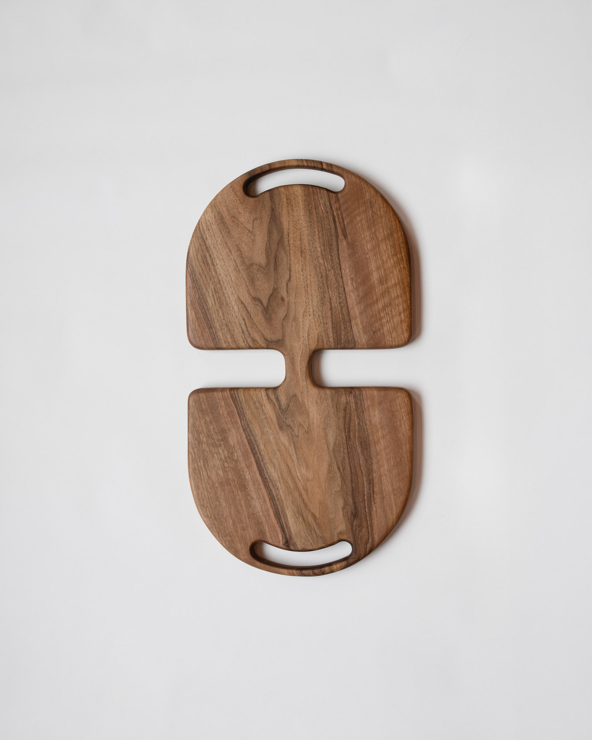 Lucas Castex No. 12 Hand-Carved Walnut Wood Serving Board on light color background.