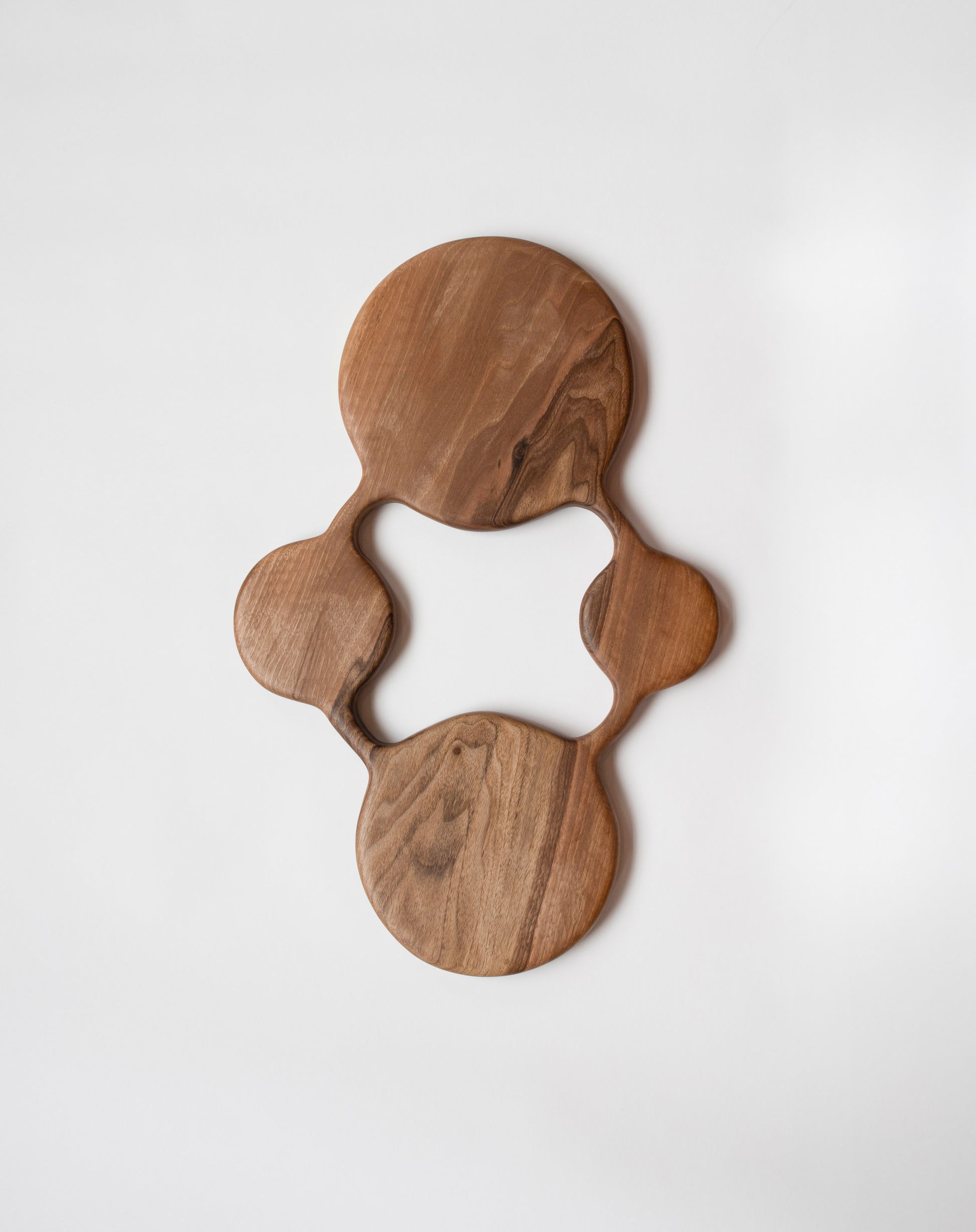 Lucas Castex No. 13 Hand-Carved Walnut Wood Serving Board on light colored background.