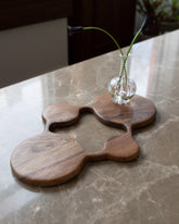 Styled image featuring the Lucas Castex No. 13 Hand-Carved Walnut Wood Serving Board.