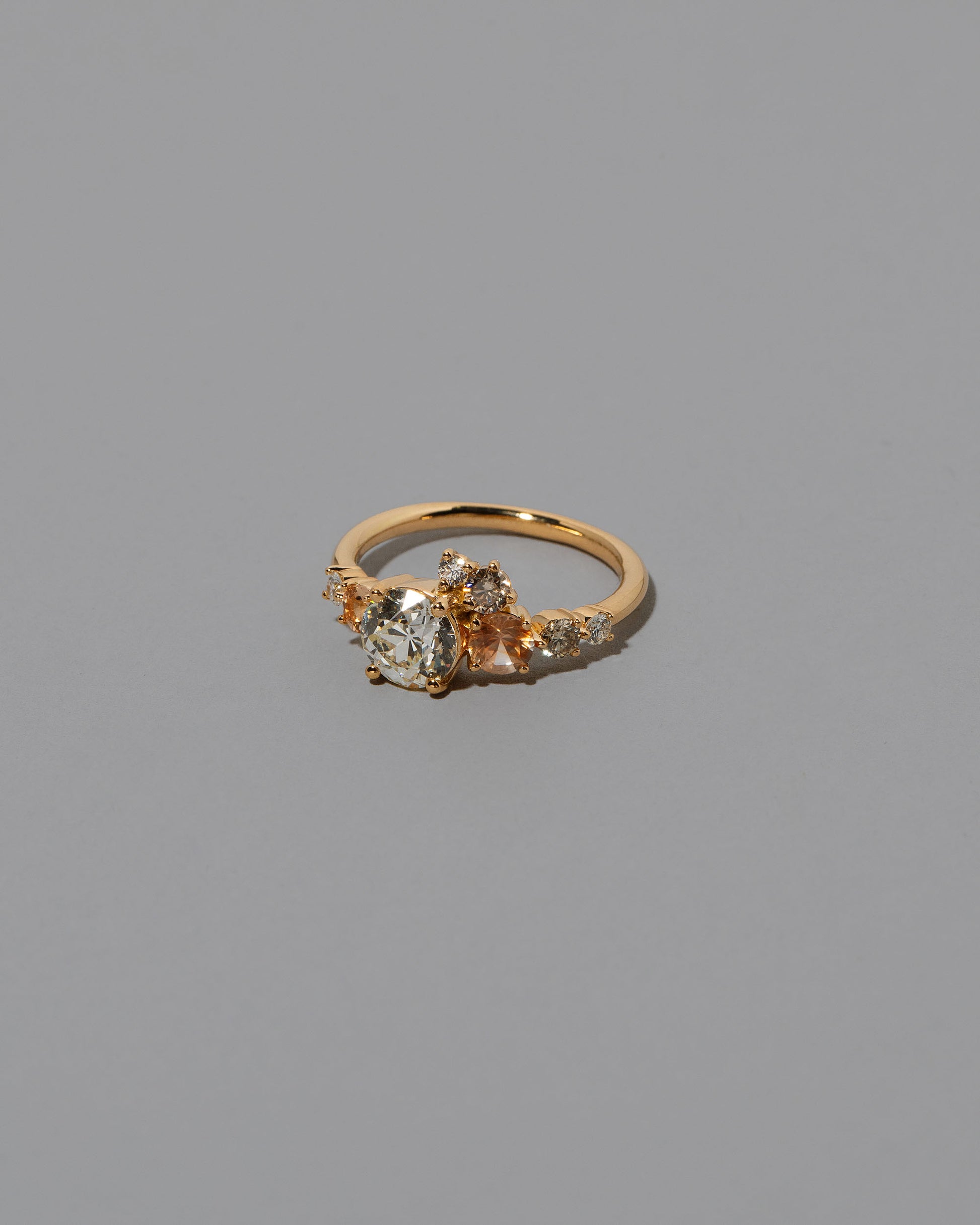 View from the side of the Peach Sapphire & Diamonds Luna Ring on light color background.