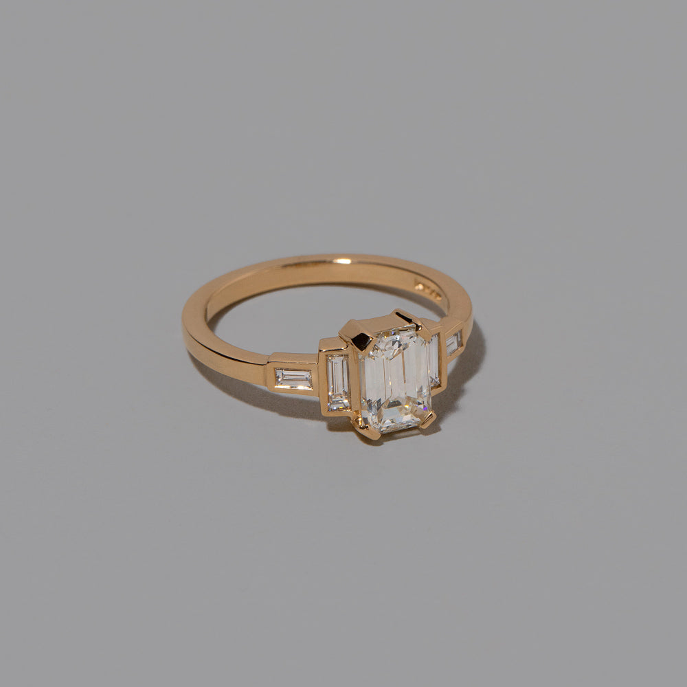 product_details::Closeup details of the Diamond Assertion Ring on light color background.