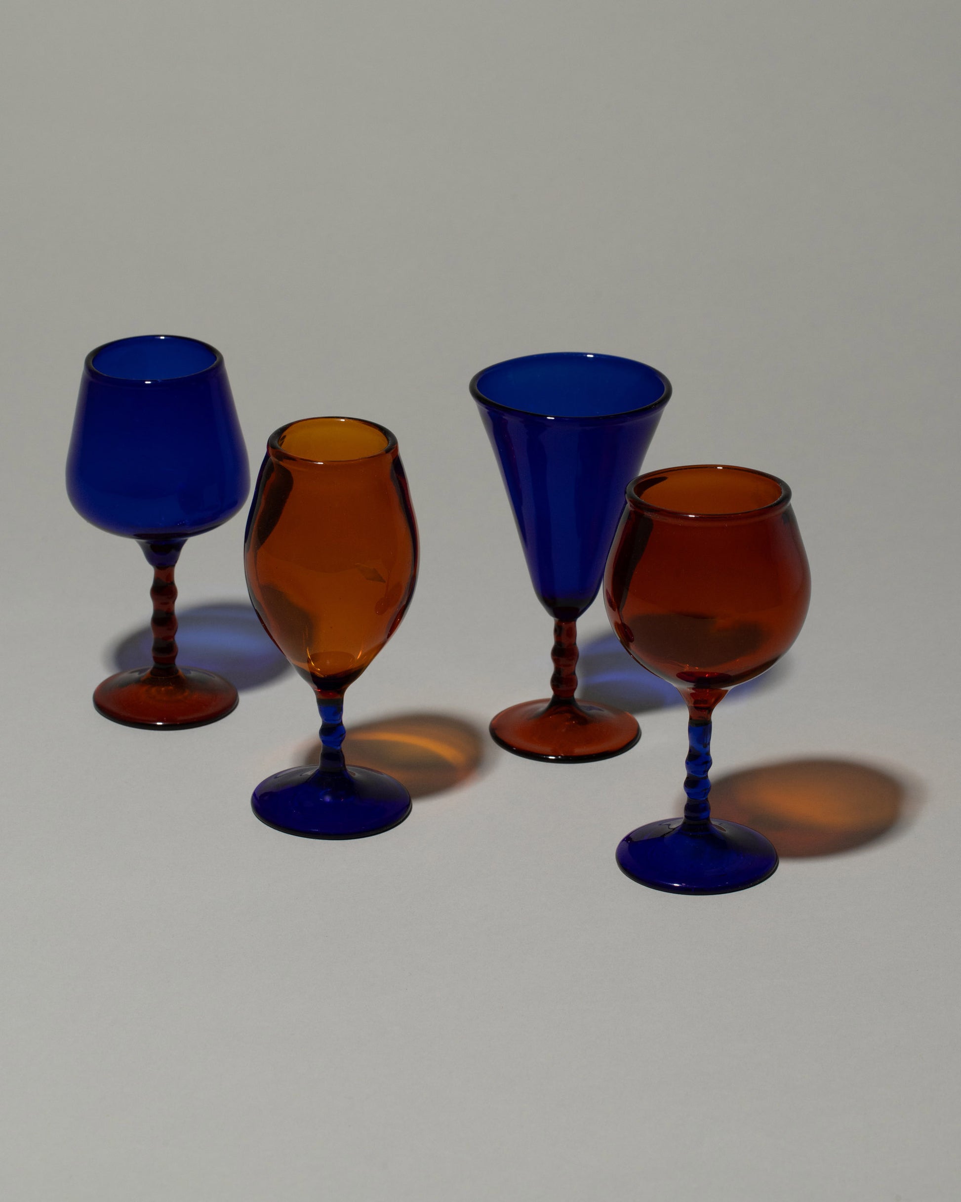 Closeup details of the Ornamental by Lameice Amber & Royal Blue Dreamlike Cordial Glass Set on light color background.