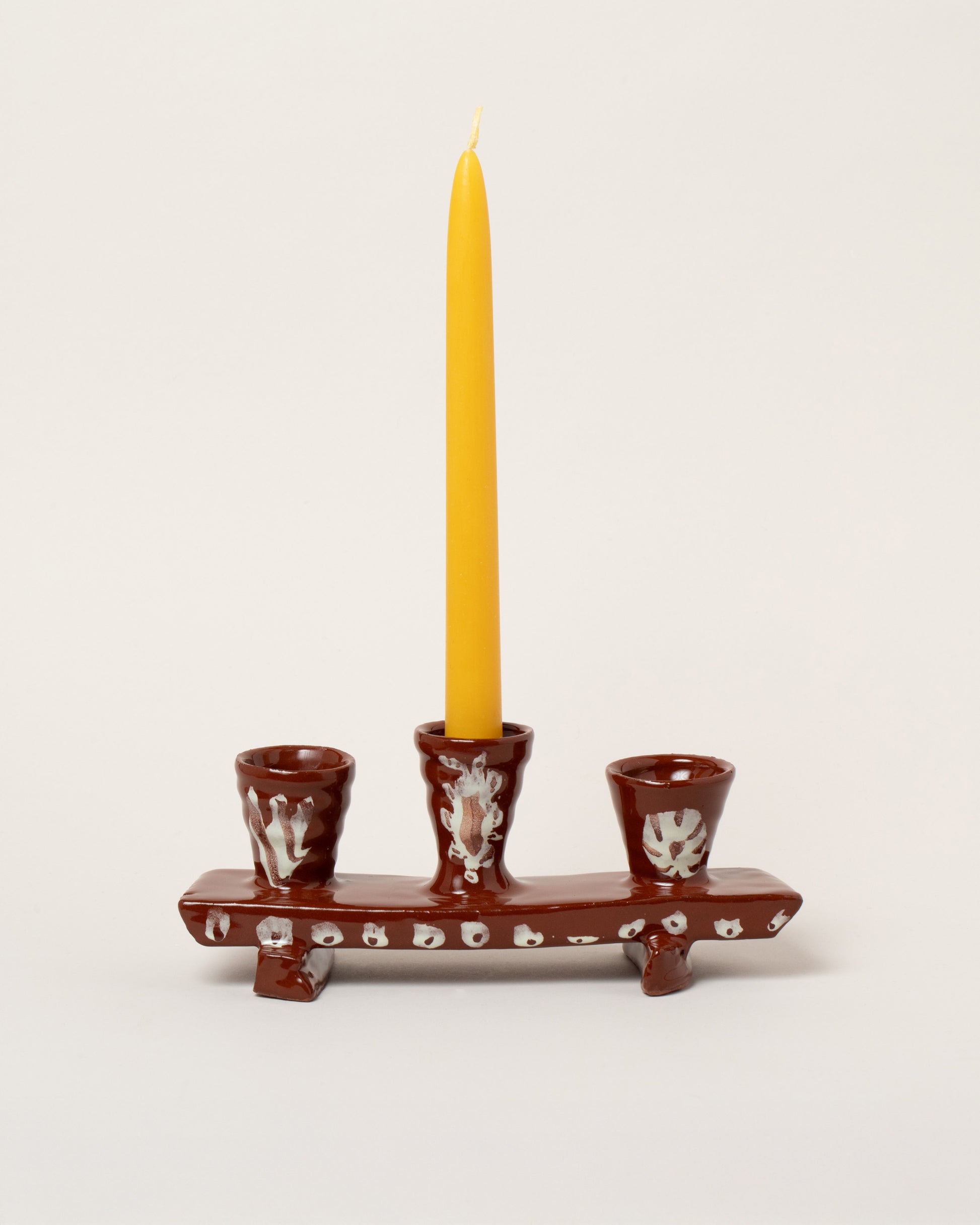 Maggie Boyd Brown Bench Candle Holder on light color background.