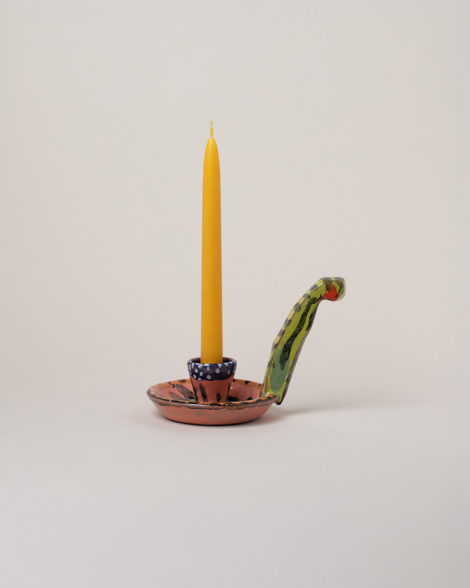 Maggie Boyd Candle Holder With Long Handle on light color background.