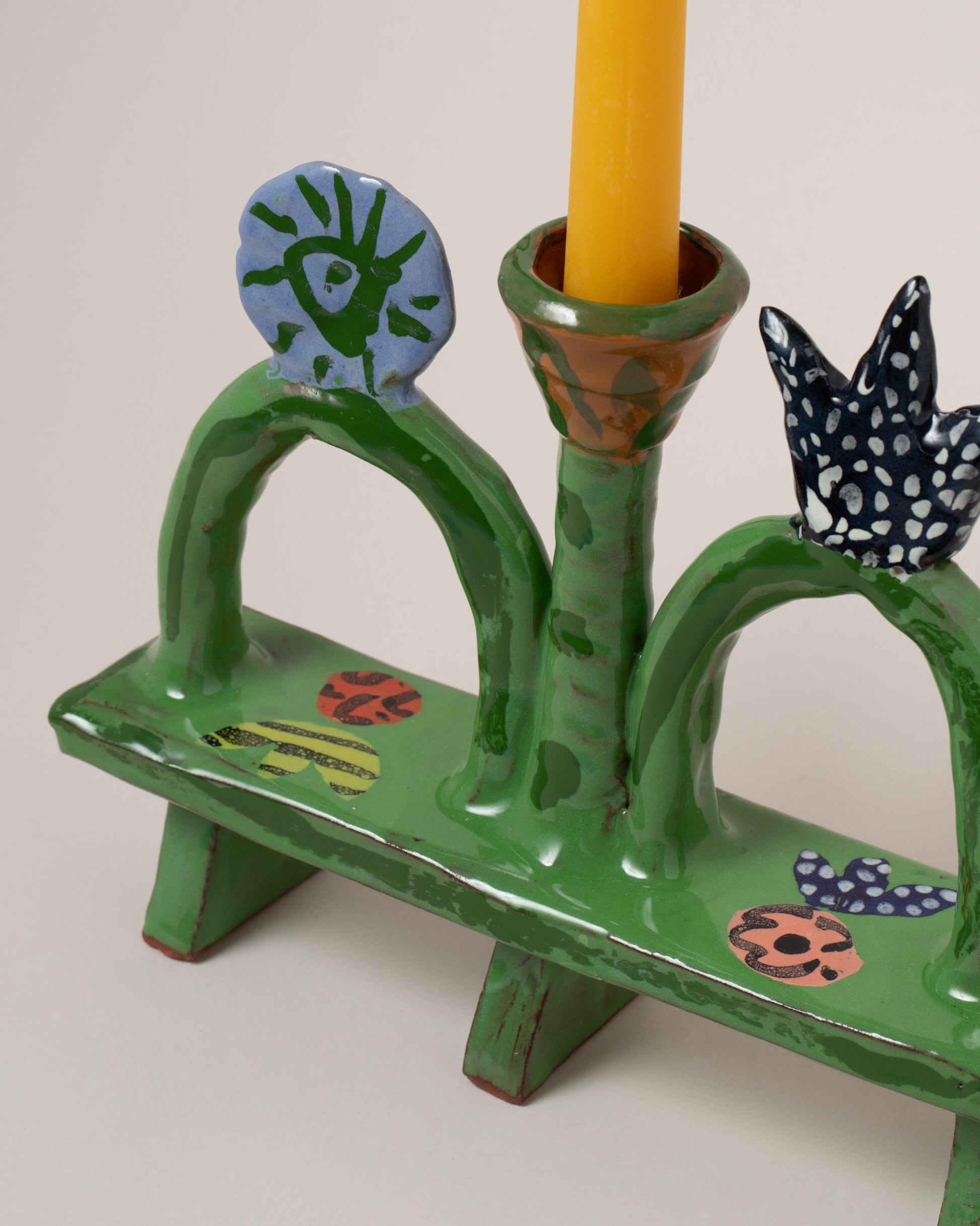 Closeup details of the Maggie Boyd PGreen Park Bench Candle Holder on light color background.