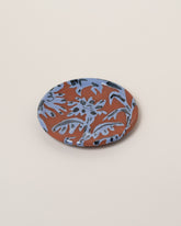 Maggie Boyd Blue One Clay Flower Side Plate on light color background.