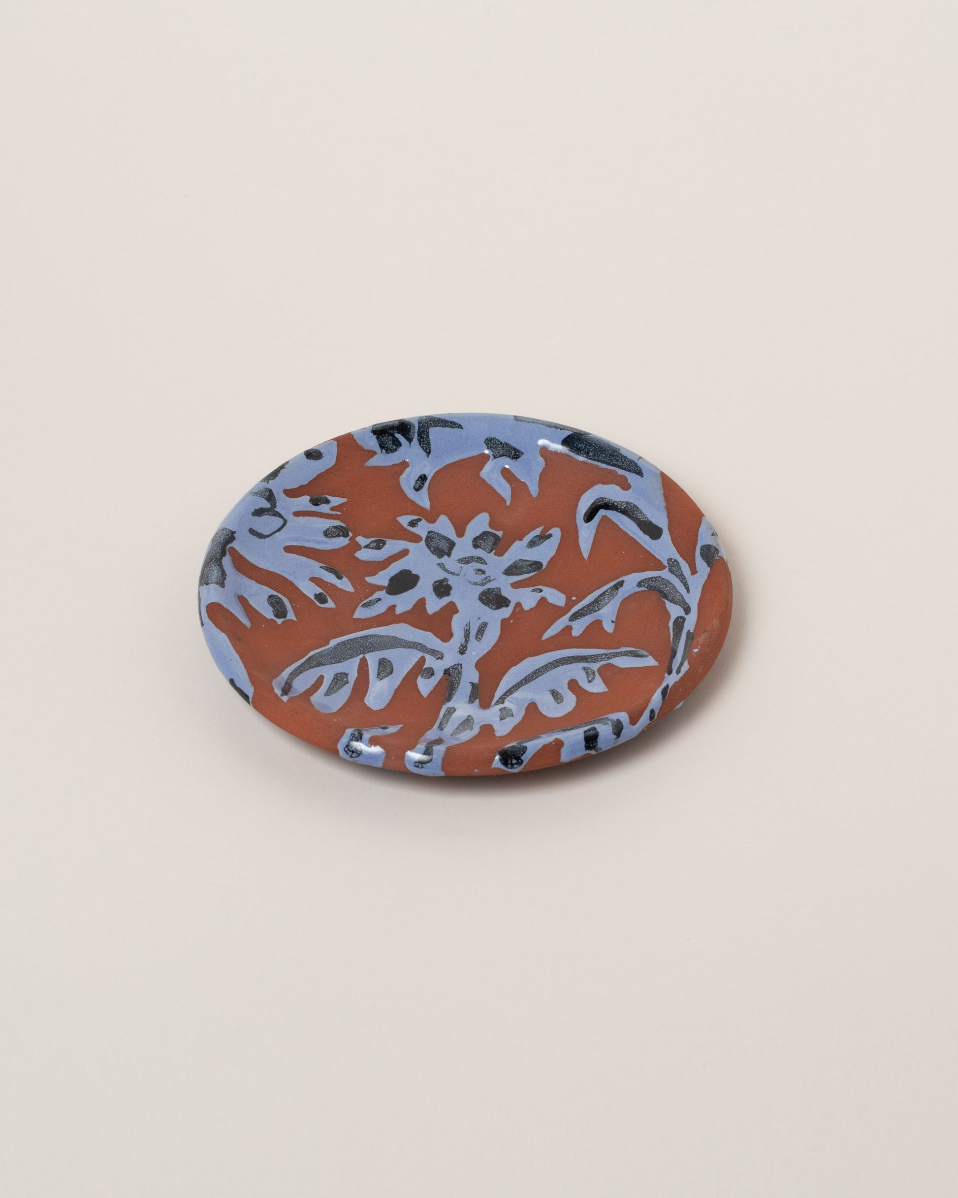 Maggie Boyd Blue One Clay Flower Side Plate on light color background.