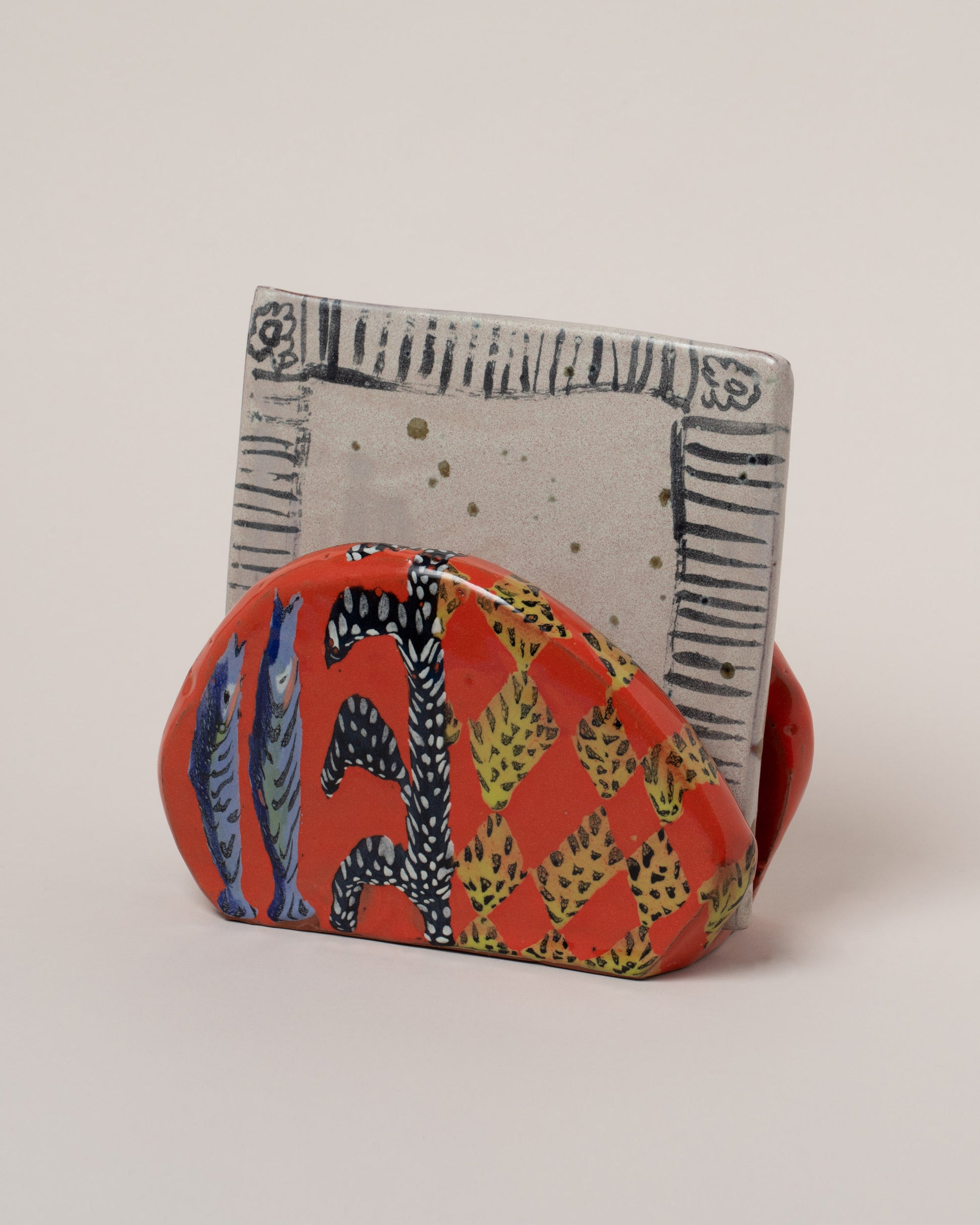 Detail view of the Maggie Boyd Napkin Holder & Trivet Set on light color background.