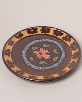 Maggie Boyd Tenmoku Flower Platter on light color background.