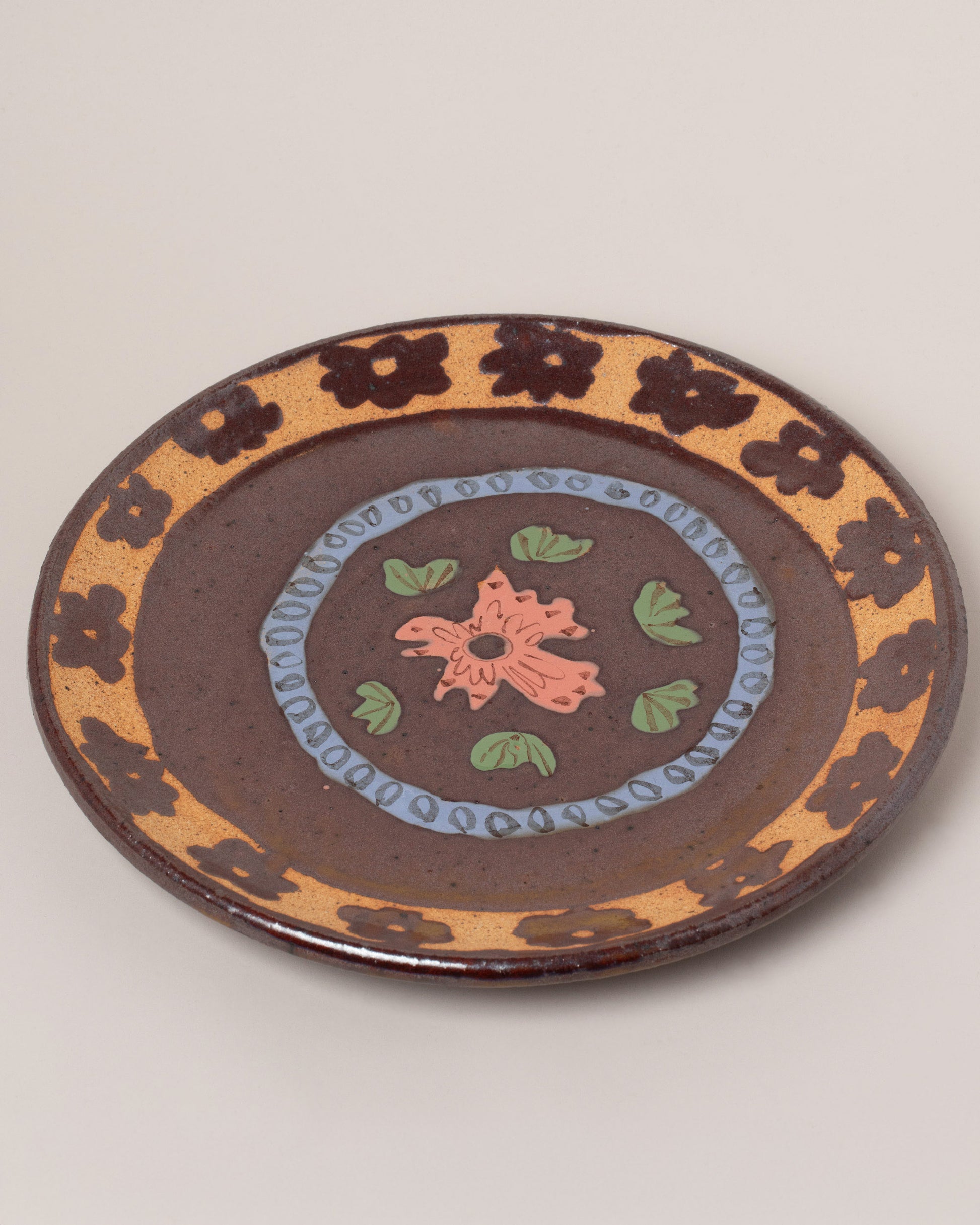 Maggie Boyd Tenmoku Flower Platter on light color background.