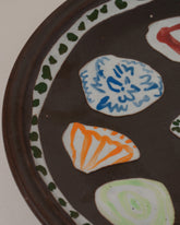 Closeup details of the Maggie Boyd Tenmoku Petal Platter on light color background.