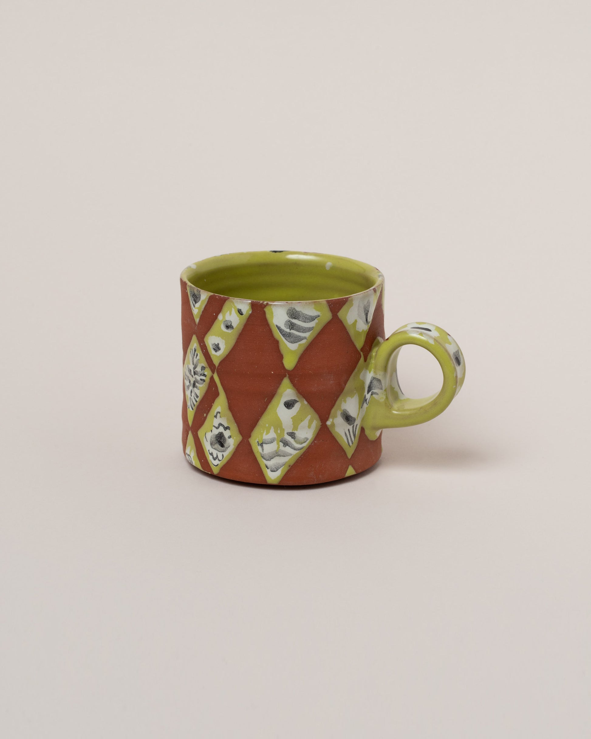 Maggie Boyd Chartreuse Jester Mug on light color background.