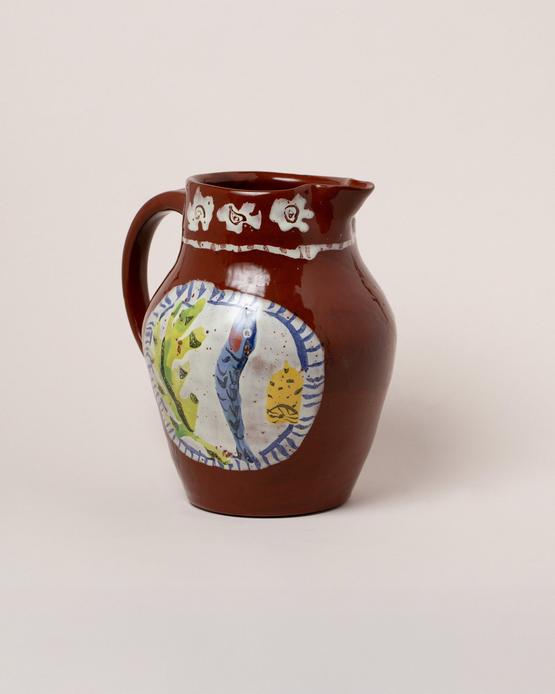 Closeup details of the Maggie Boyd Chocolate Dinner Plate Pitcher on light color background.