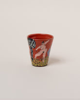 Maggie Boyd One Red Figures On Grass Tumbler on light color background.