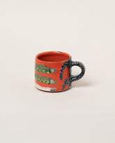 Maggie Boyd Two Red Jestercore Mug on light color background.