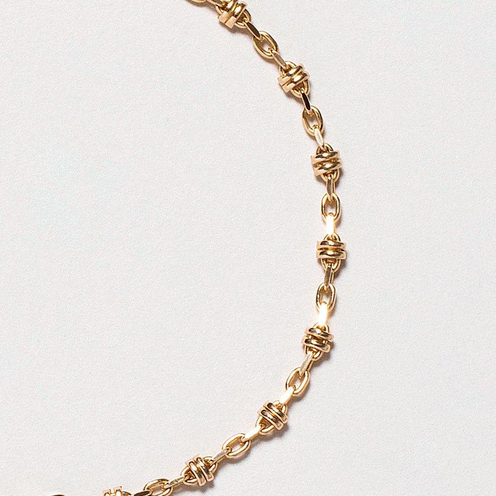 product_details::Closeup details of the Wrapped Chain Bracelet on light color background.
