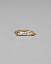 Gold Baguette Mini Curve Band on light color background.