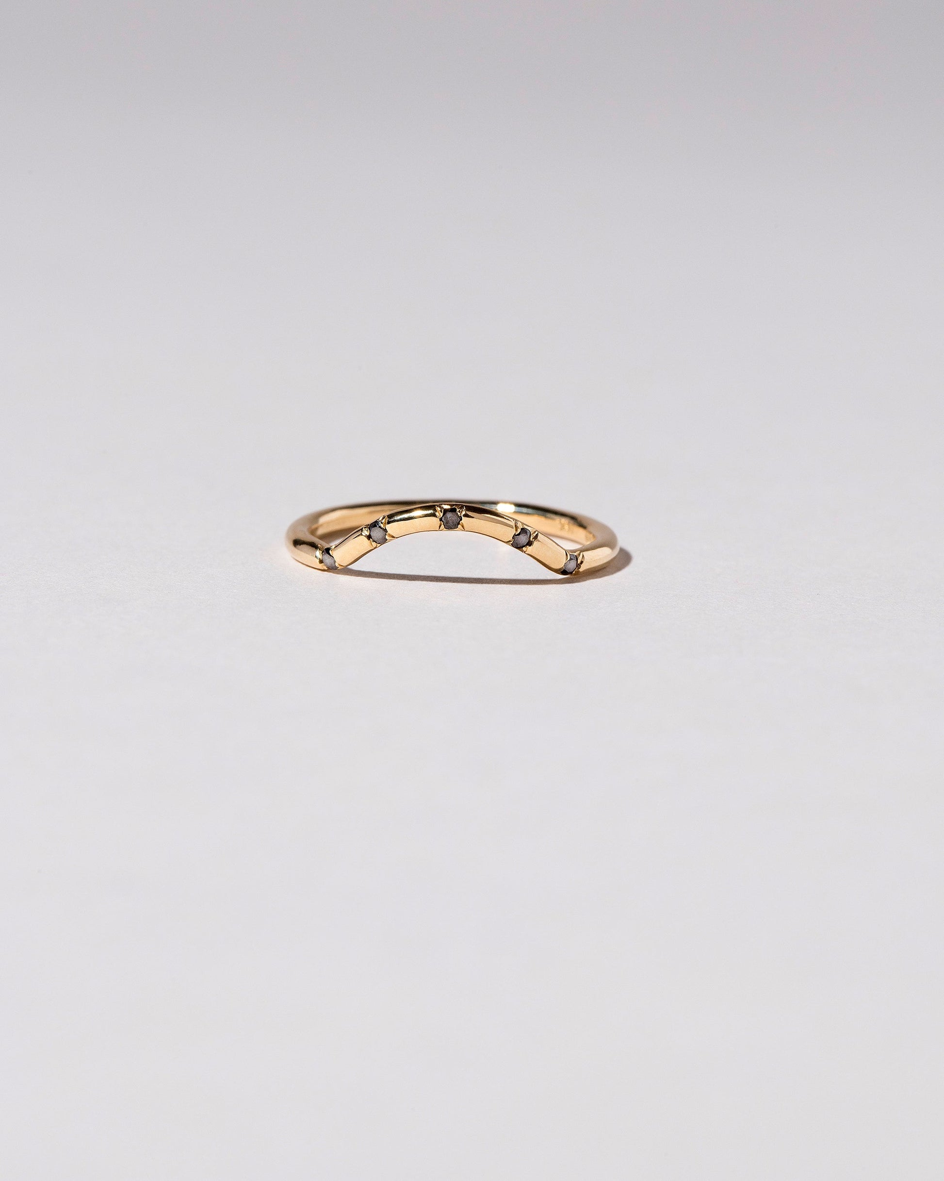 Gold Five Stone Black Diamond Mini Curve Band on light color background.