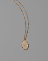 Finished Large Oval Memento Necklace on light color background.