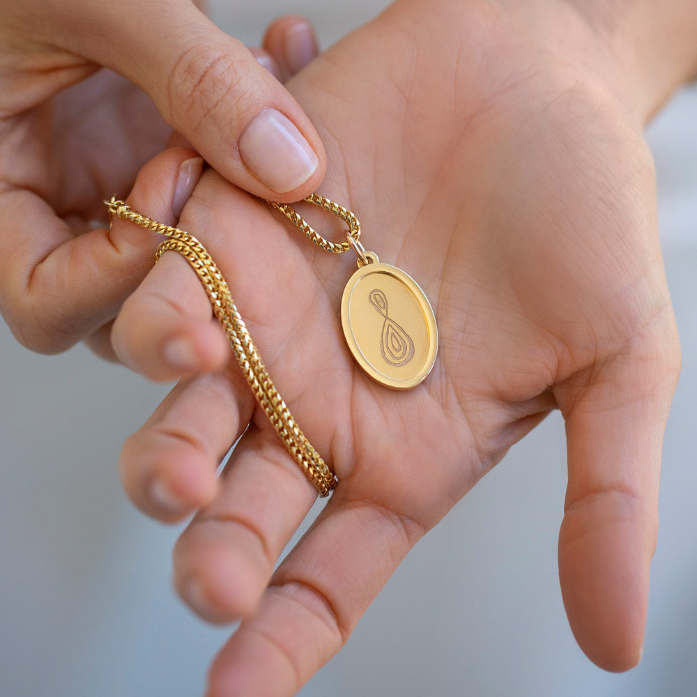 product_details::Finished Large Oval Memento Pendant in hand, paired with the Mociun 2mm 18" Ritual Chain Necklace.