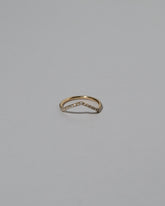 Gold White Diamond Infinity Pavé Luna Peak Band on light color background.