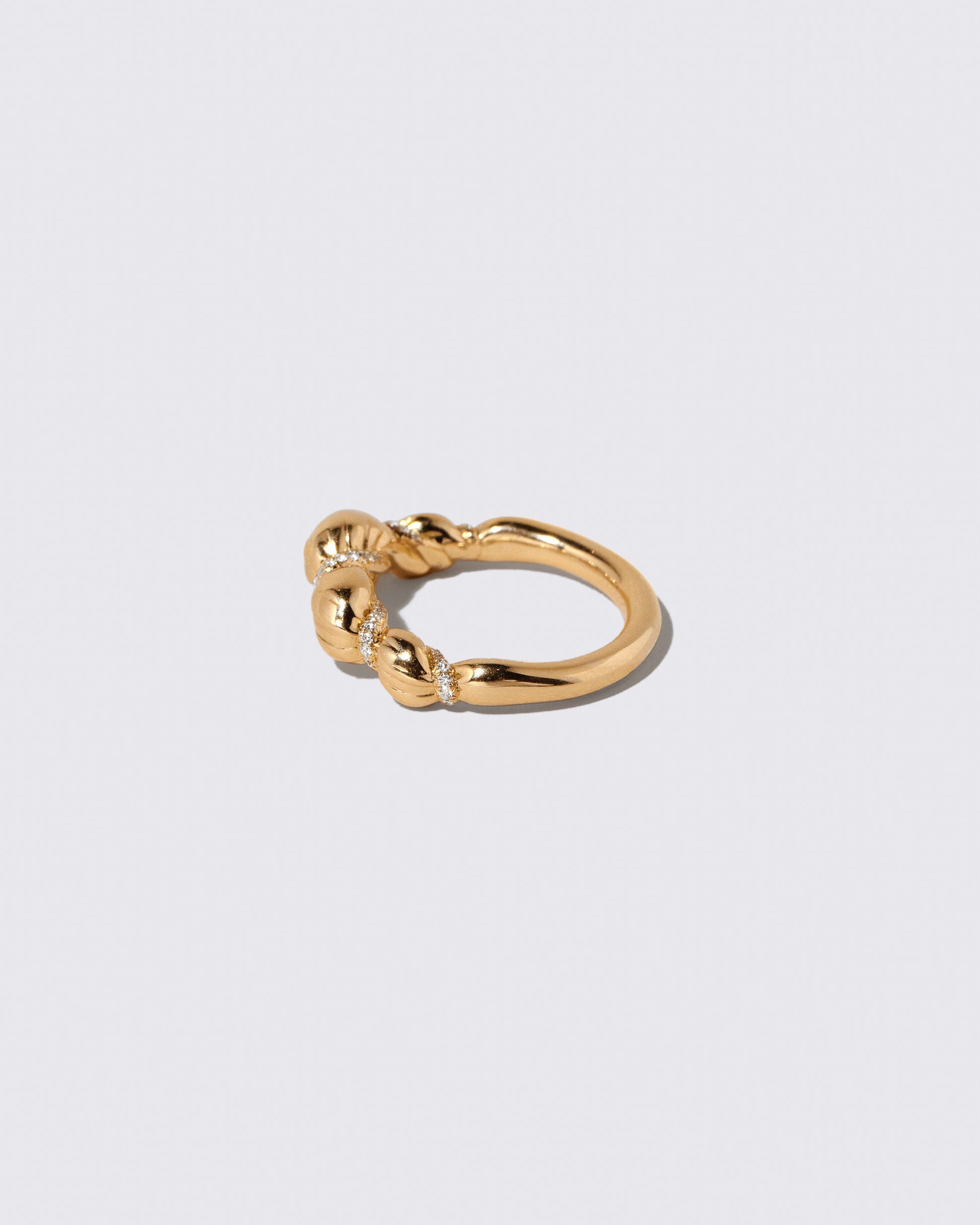 View from the back of the Gold Pavé Bind Band on light color background.