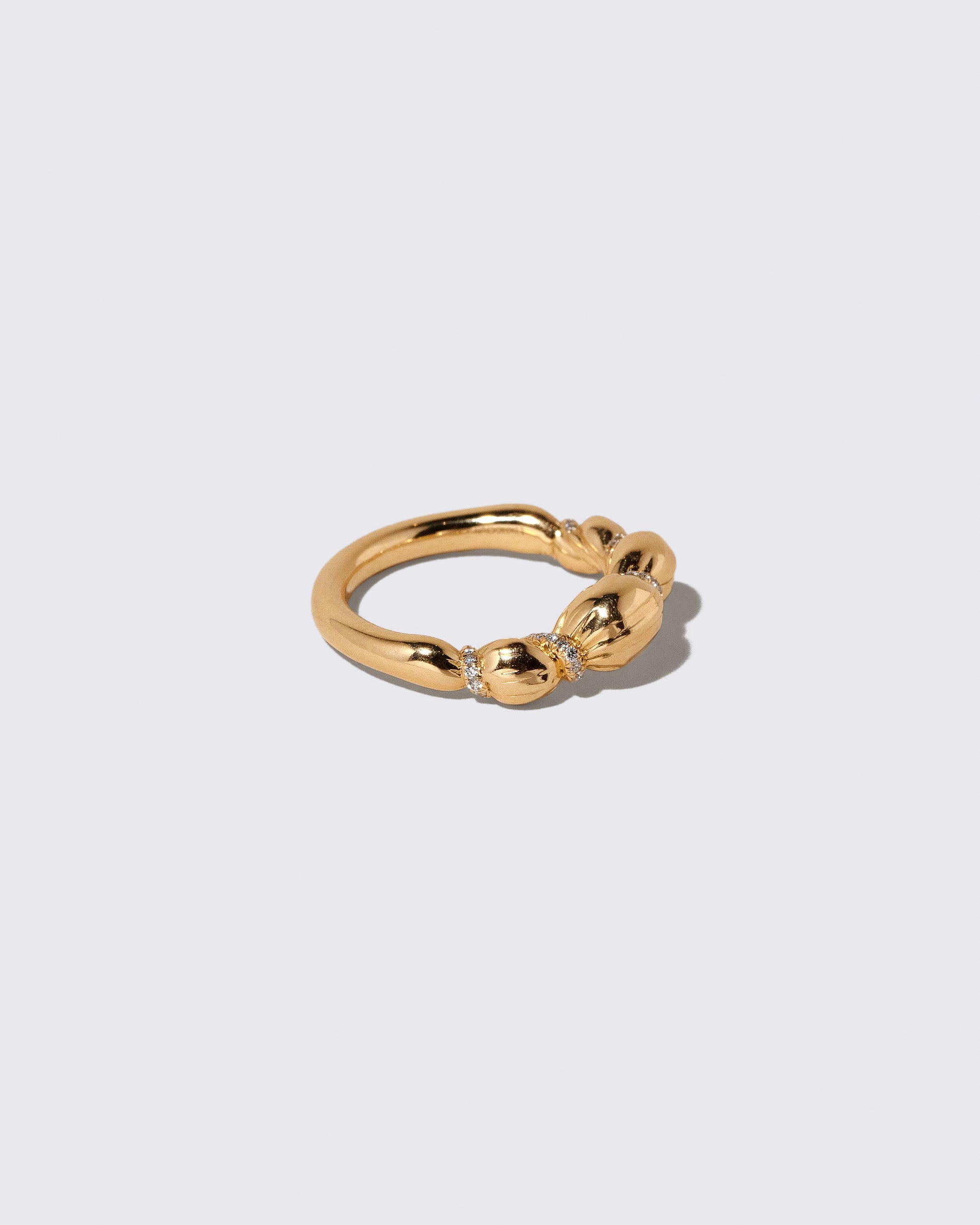View from the side of the Gold Pavé Bind Band on light color background.