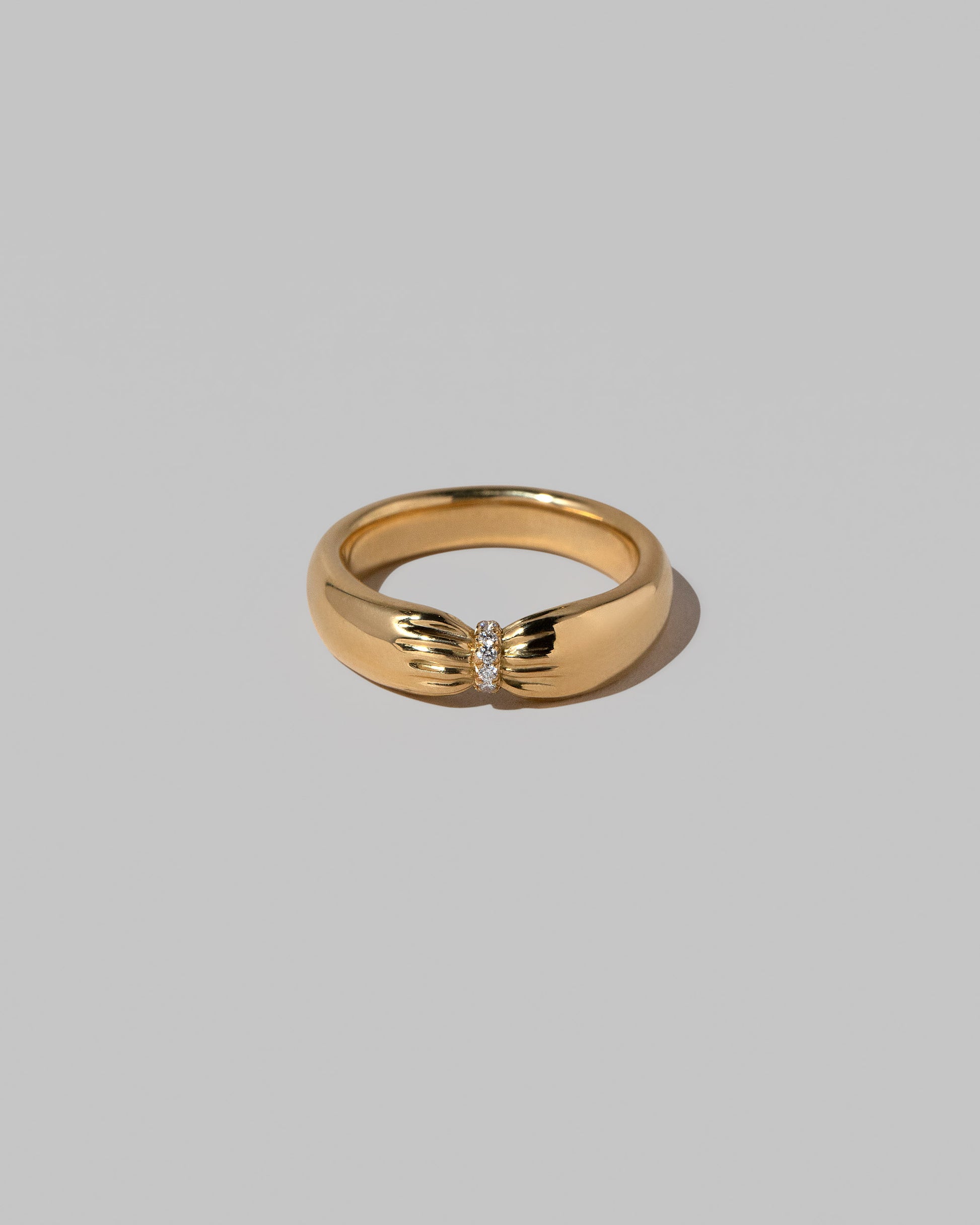 Gold Pavé Pinch Band on light color background.