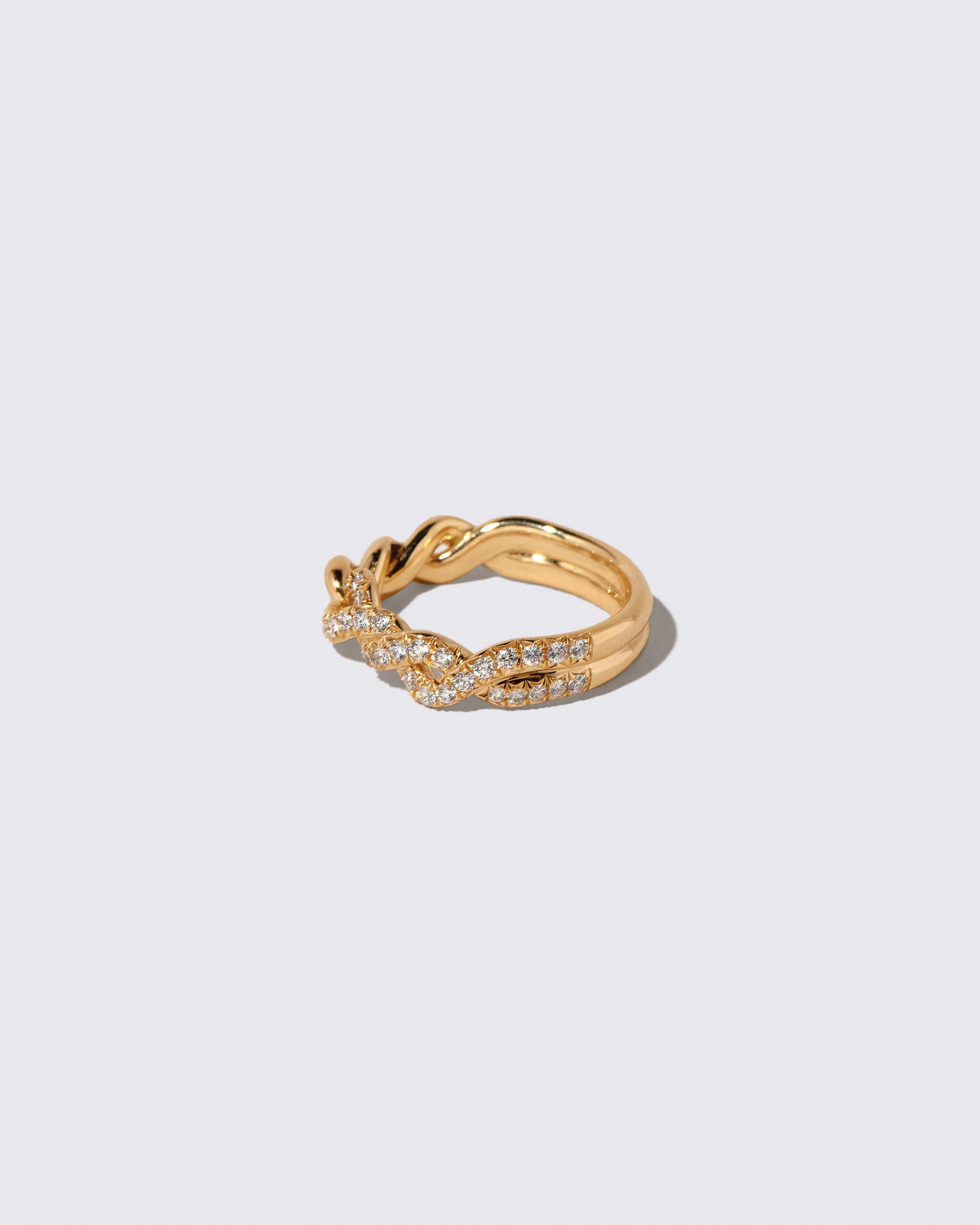 View from the back of the Gold Pavé Twist Band on light color background.