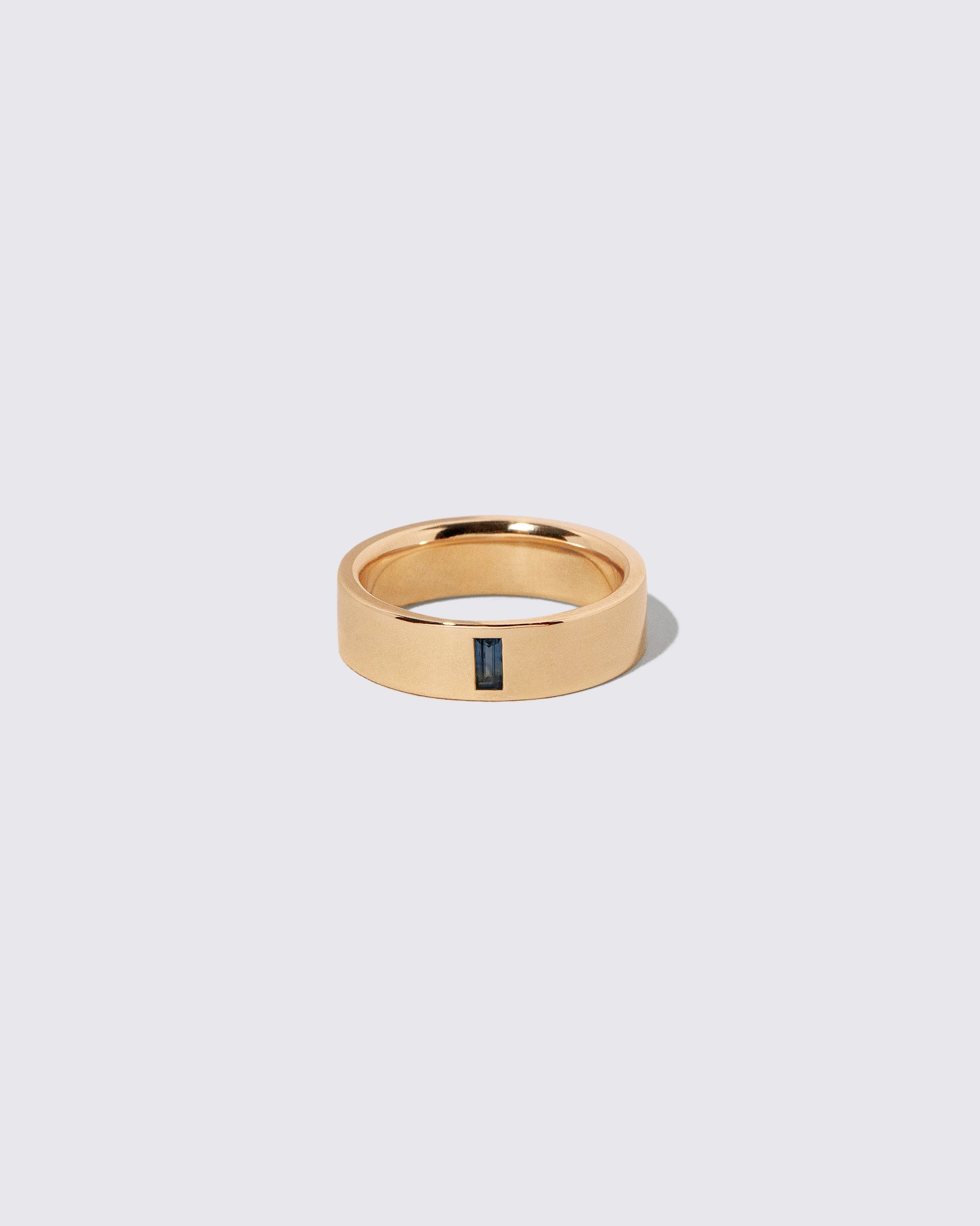 Gold Australian Bicolor Sapphire North South 6mm Baguette-Set Piet Band on light color background.