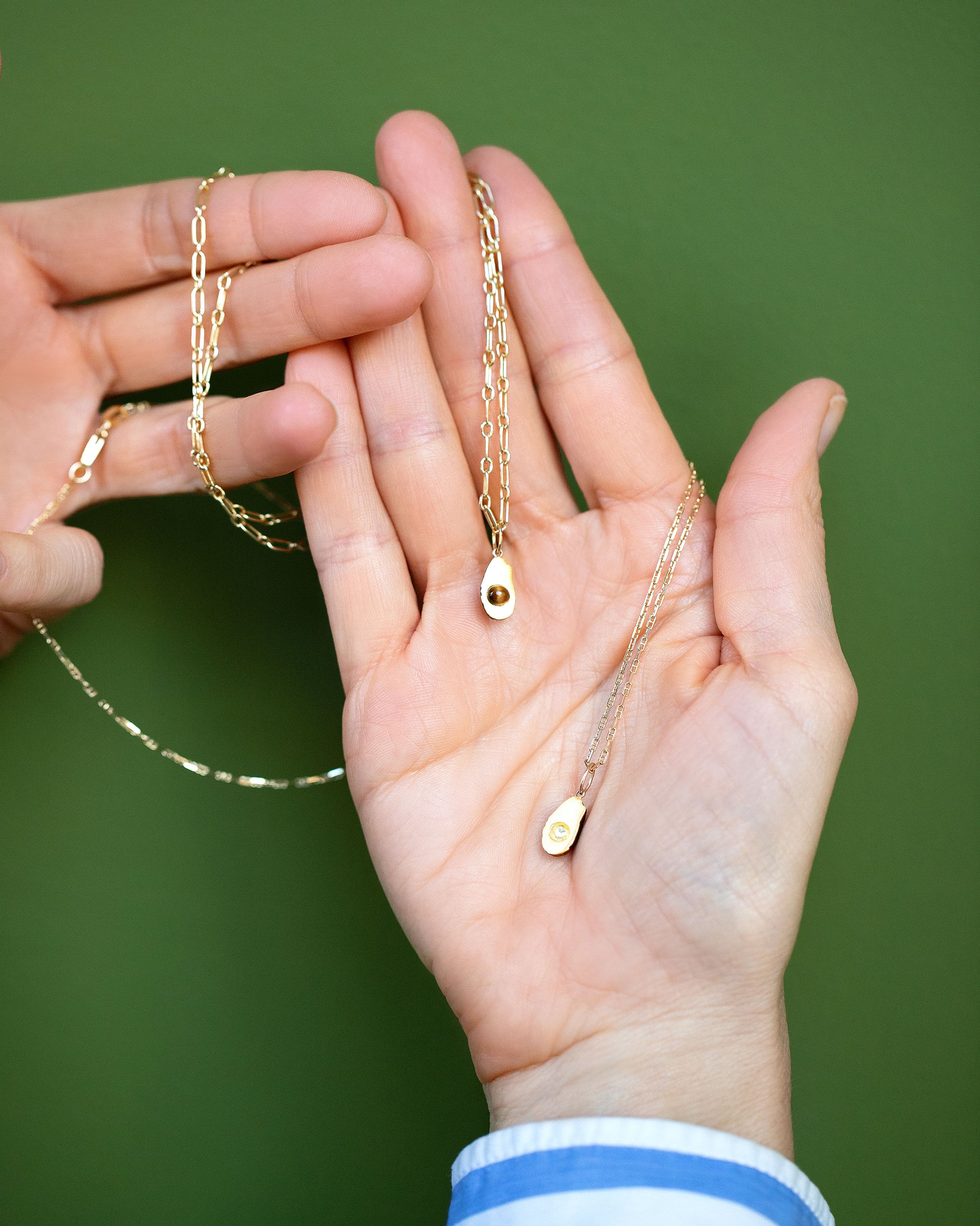 Hot Dog Chain Necklace with the 'pitted' Halved Avocado Charm and Petite Diamond Cut Chain Necklace with the 'pitless' Halved Avocado Charm on model.