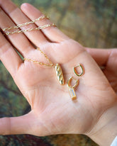 Hot Dog Chain Necklace with Demi Baguette Charm and Stick of Salted Butter Charm paired with the Huggie components of the Solid Gold Link Huggie Hoop Earrings on model.