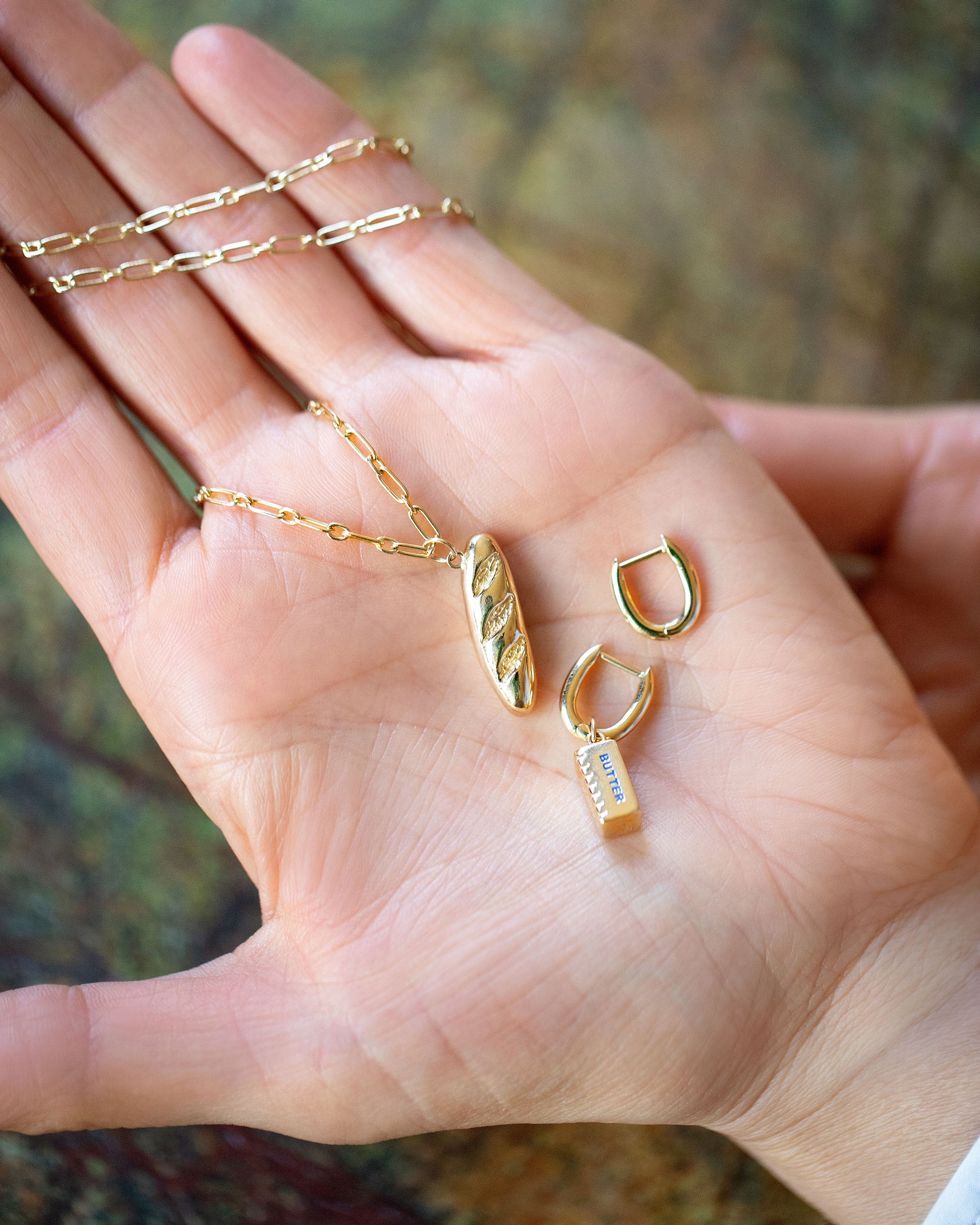 Hot Dog Chain Necklace with Demi Baguette Charm and Stick of Salted Butter Charm paired with the Huggie components of the Solid Gold Link Huggie Hoop Earrings on model.