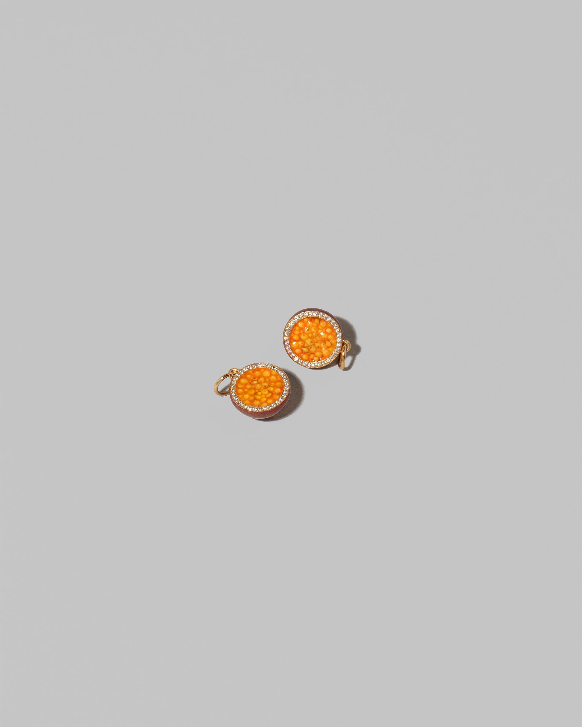 Halved Passion Fruit Charms on light color background.