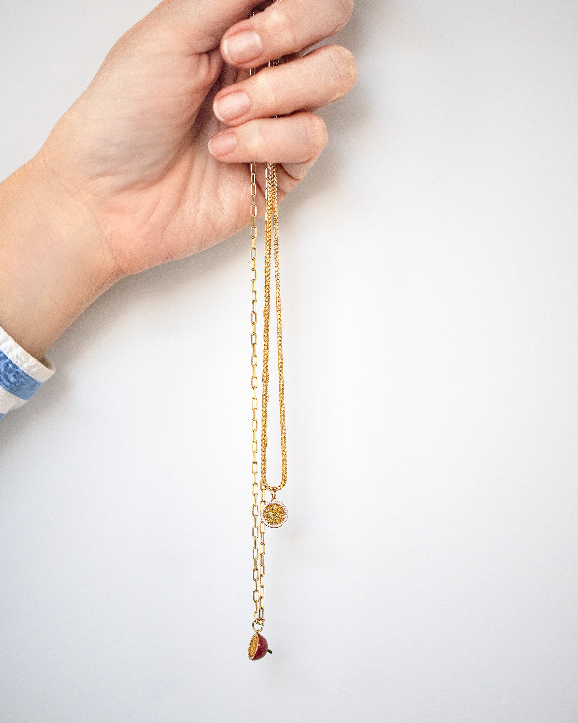 Halved Passion Fruit Charms with the 2.2mm Beveled Oval Chain Necklace and 1.5mm Ritual Chain Necklace on model.