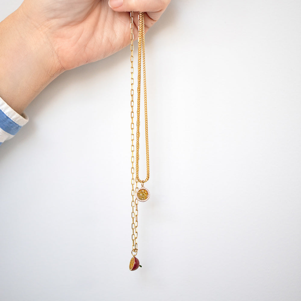 product_details::Halved Passion Fruit Charms with the 2.2mm Beveled Oval Chain Necklace and 1.5mm Ritual Chain Necklace on model.