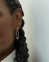 Styled image on model featuring the Pearl Link Huggie Hoop Earrings.