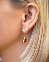 Red Lover's Kiss Charm and Classic Gold Solid Snack Hoop Earrings with Huggie Gold Diamond Snack Hoop Earrings on model.