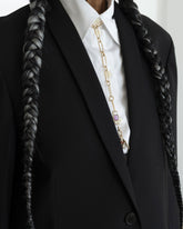Styled image on model featuring the Sapphire Gusher Openable Pendant connected to a closed-loop oval link of the Link Necklace worn as a lariat, and a Bruised Banana Peel Charm and Red Apple Core Charm suspended from its Gold Coiled Swivel Charm Holder clasp.