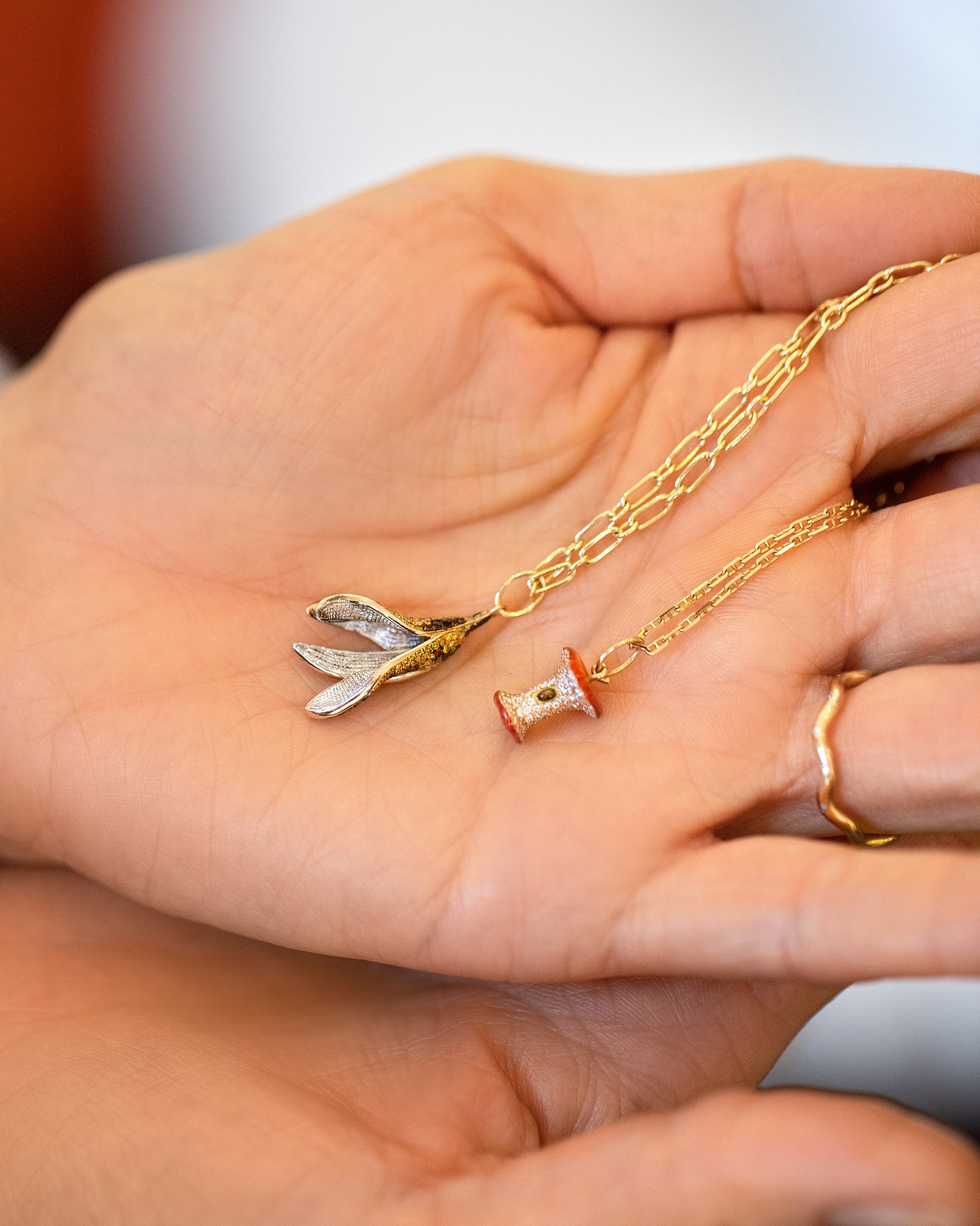 Hot Dog Chain Necklace with Bruised Banana Peel Charm, Red Apple Core Charm with Petite Diamond Cut Chain Necklace and Gold Bump Band on model.