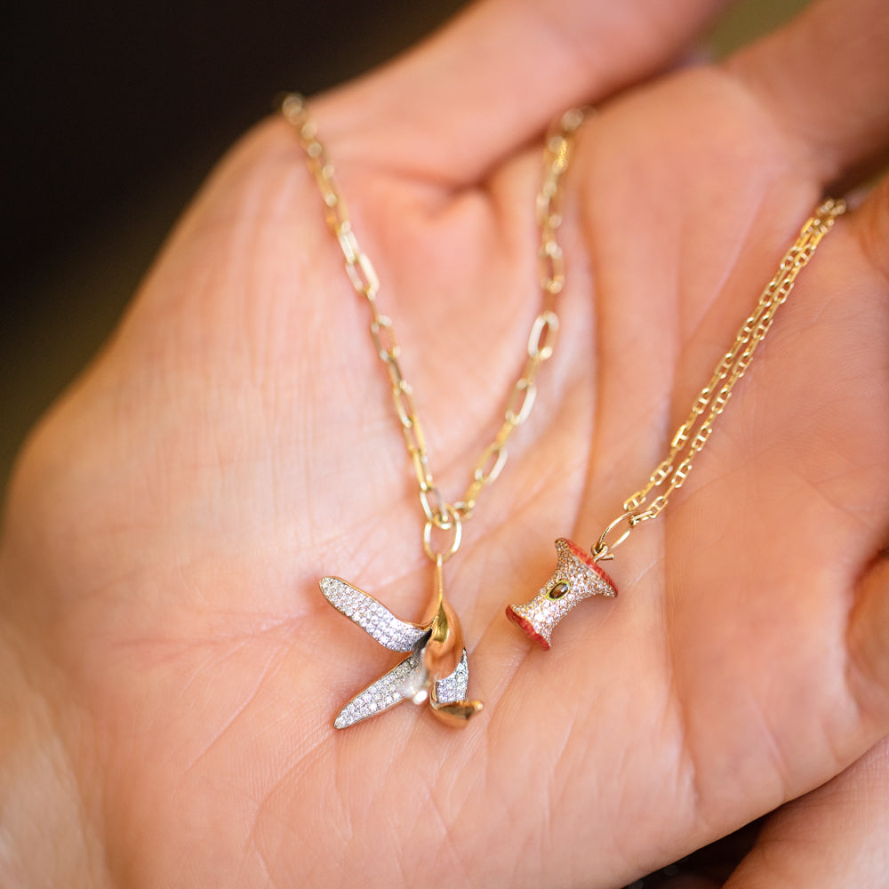 product_details::2.2mm Beveled Oval Chain Necklace with Banana Peel Charm, Red Apple Core Charm with Petite Diamond Cut Chain Necklace and Gold Bump Band on model.