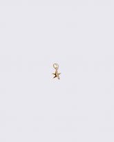 Gold Verve Five Point Star Charm on light color background.