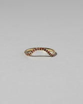 Gold Pavé Garnet Curve Band on light color background.