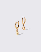 Yellow Sapphire Gusher Charm Huggie Hoop Earrings on light color background.