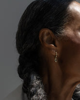 Styled image on model featuring the Yellow Sapphire Gusher Charm Huggie Hoop Earrings.
