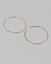 Large Pave Diamond Hoop Earrings on light color background.