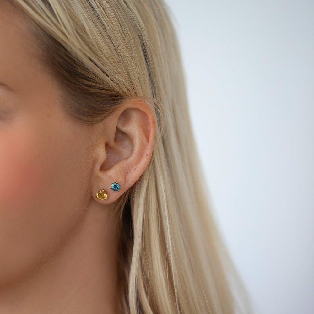 product_details::Mega Yellow Beryl Martini Stud Earring and Blue Sapphire Martini Stud Earring on model.